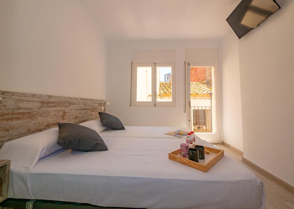 罗萨斯Agi Gloria Rooms的卧室设有一张白色大床和一扇窗户。