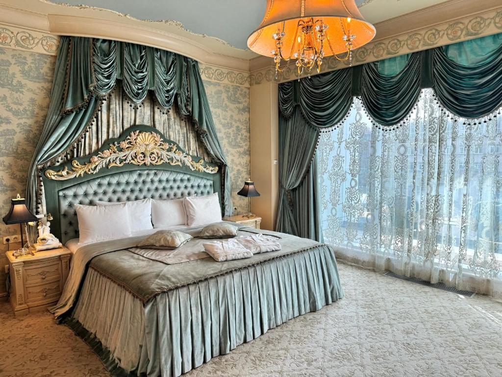 里加Royal SPA & Hotel Resort的一间卧室配有一张大床和一个吊灯。