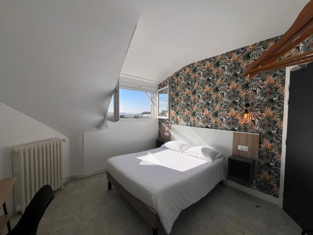 洛里昂Hôtel Le Keroman的一间卧室配有一张带花卉图案墙壁的床