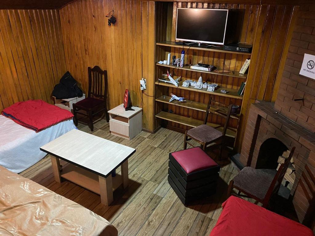 第比利斯ARTISHA TRAVEL TBILISI的客房设有两张床、一台电视和一个壁炉。