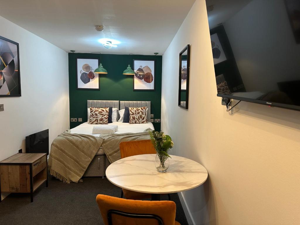 彼得伯勒Newark House Premium Apartments by DH ApartHotels的一间卧室配有一张床和一张桌子及椅子