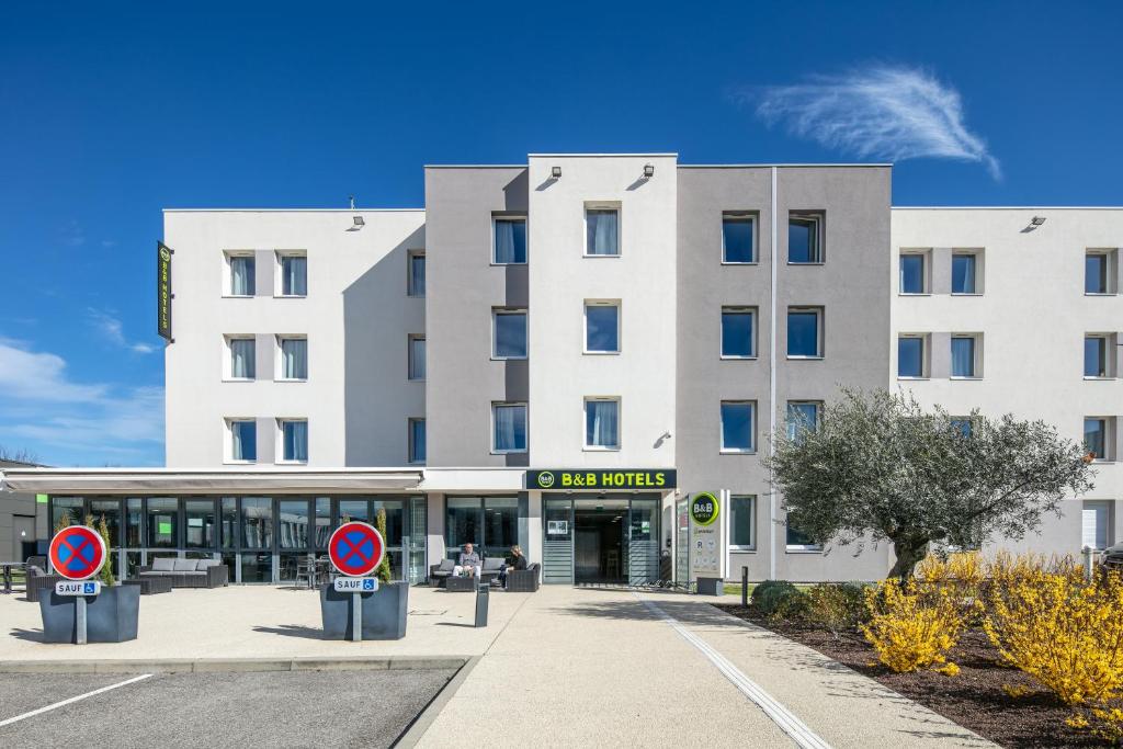 圣康坦法拉维耶B&B HOTEL Lyon Aéroport Saint-Quentin-Fallavier的天空中一片云的白色大建筑