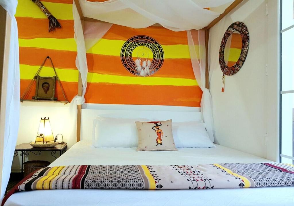 拉马萨The African Story的一间卧室配有一张带彩色墙壁的床