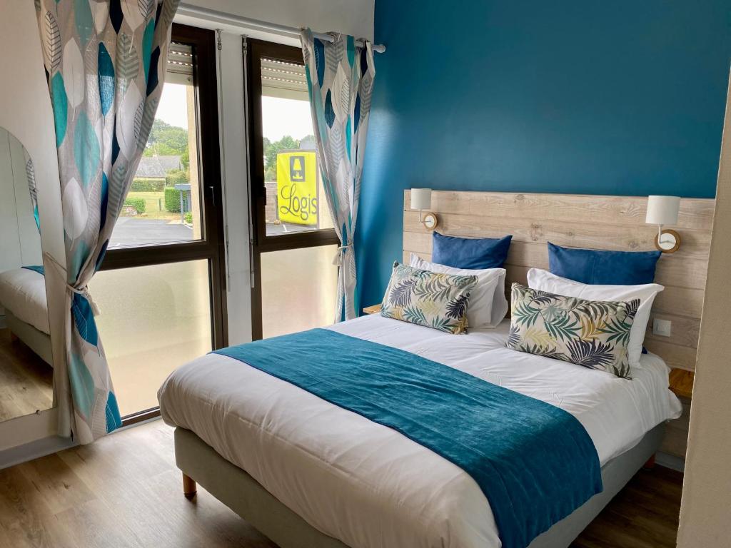 La Breille-les-PinsLogis Hotel Restaurant l'Orée Des Bois的一间卧室配有一张蓝色墙壁的床和一扇窗户