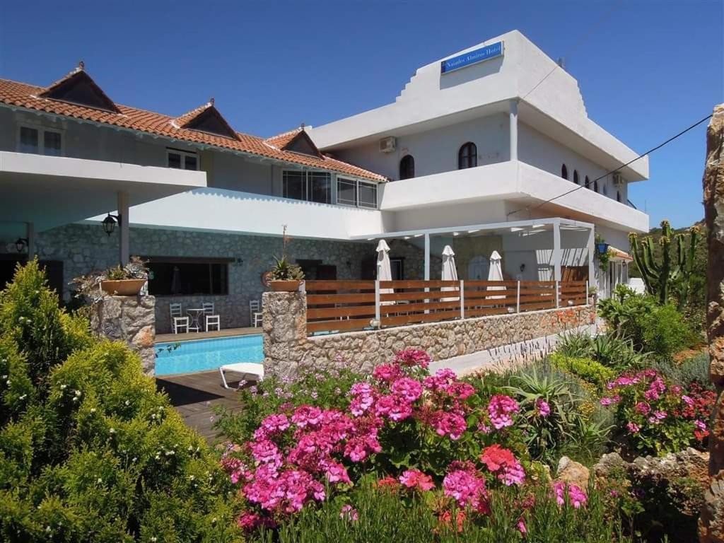 阿基欧斯尼古拉斯Naiades Almiros Hotel的一座带游泳池和鲜花的大房子