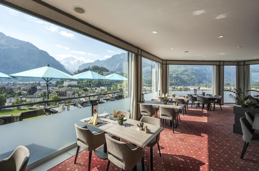 因特拉肯瑞士品质都市酒店的一间带桌椅的山景餐厅
