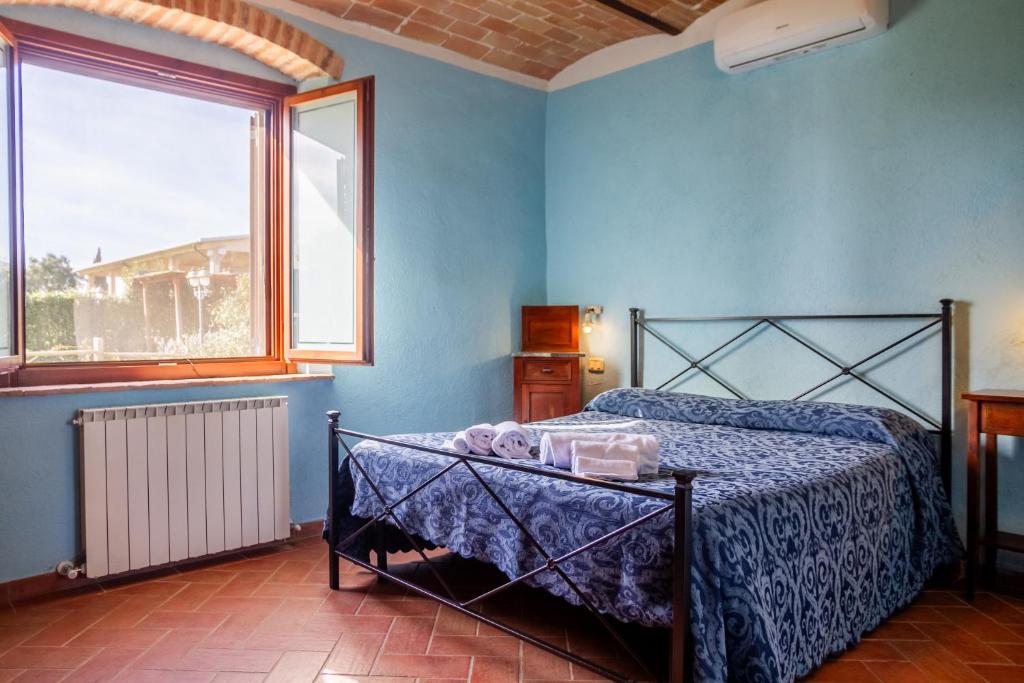 布拉卡尼Le Gerlette - La Stalla的一间卧室配有一张蓝色墙壁的床和一扇窗户