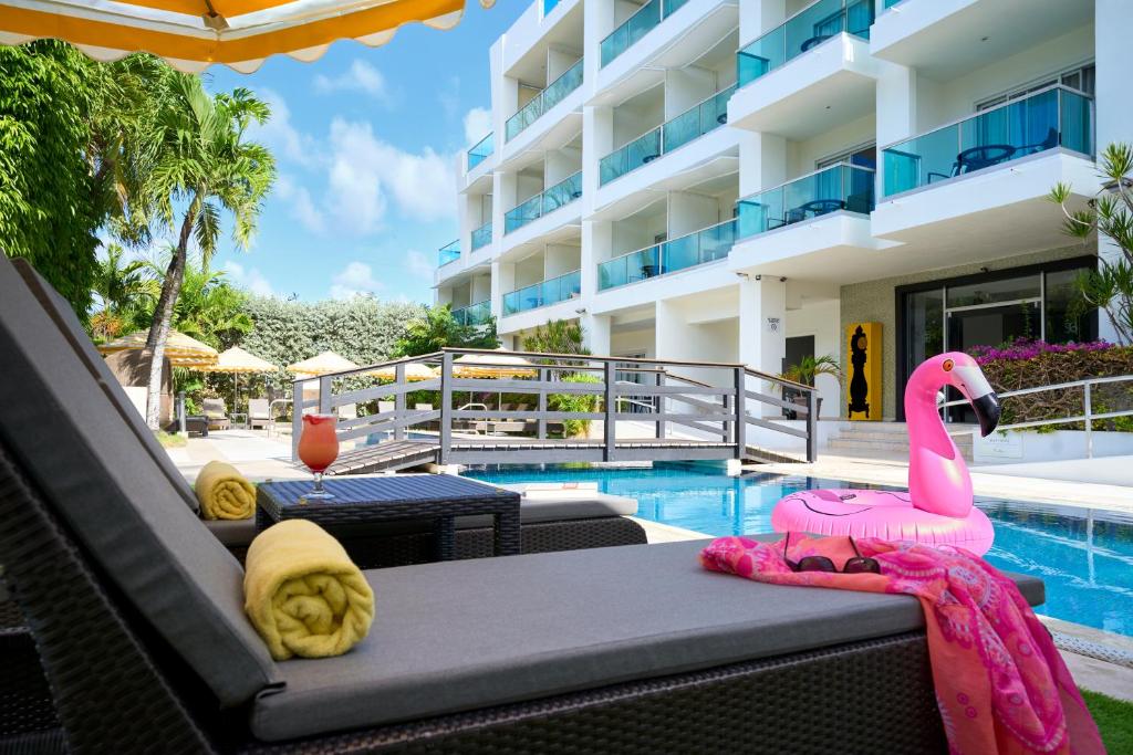 布里奇敦The Rockley by Ocean Hotels - Breakfast Included的游泳池旁桌子上摆放着粉红色的火烈鸟玩具