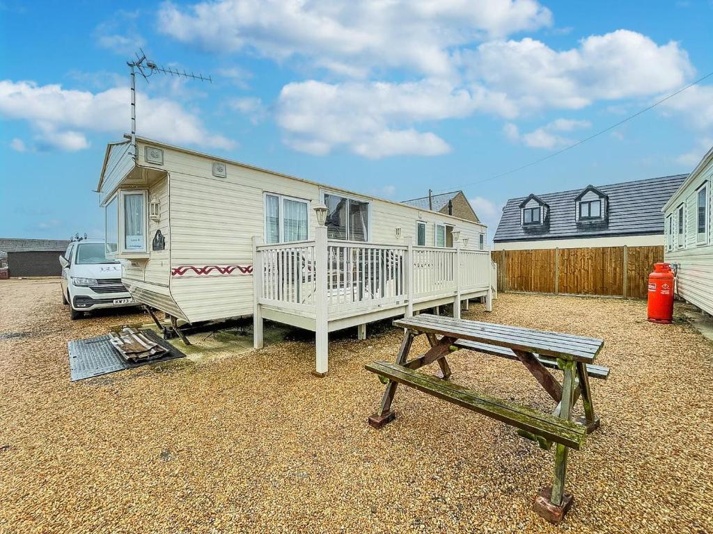 亨斯坦顿6 Berth Caravan In Hunstanton, Ideal For Seaside Holidays Ref 13004l的配有野餐桌和长凳的房子