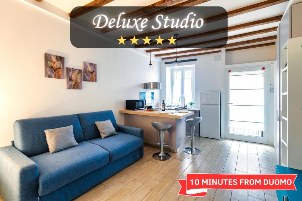 米兰Duomo in 10 minutes - modern close to Cadorna Station的一间带蓝色沙发的客厅和一间厨房