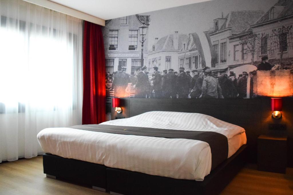 阿默斯福特Bastion Hotel Amersfoort的卧室配有一张大床,墙上挂有壁画