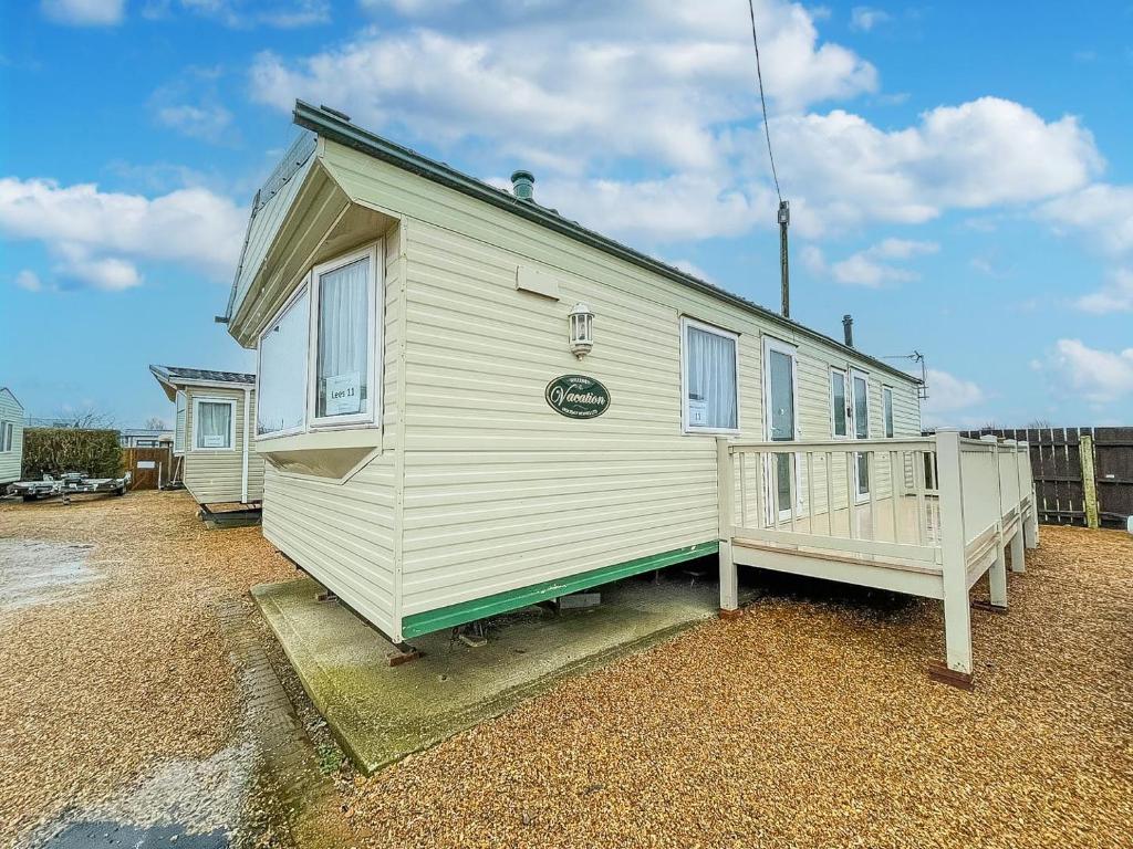 亨斯坦顿6 Berth Pet Friendly Static Caravan By Hunstanton Beach Ref 13011l的白色的小房子,设有门廊