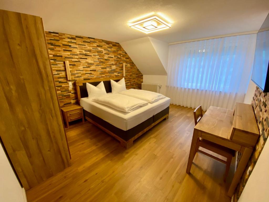 策尔廷根-拉蒂希Hotel Restaurant Unikat的一间卧室设有一张床和砖墙
