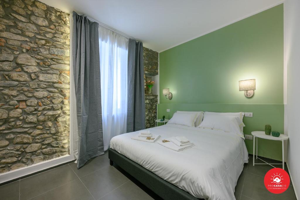 斯培西亚SEICENTO的一间卧室设有一张大床和石墙