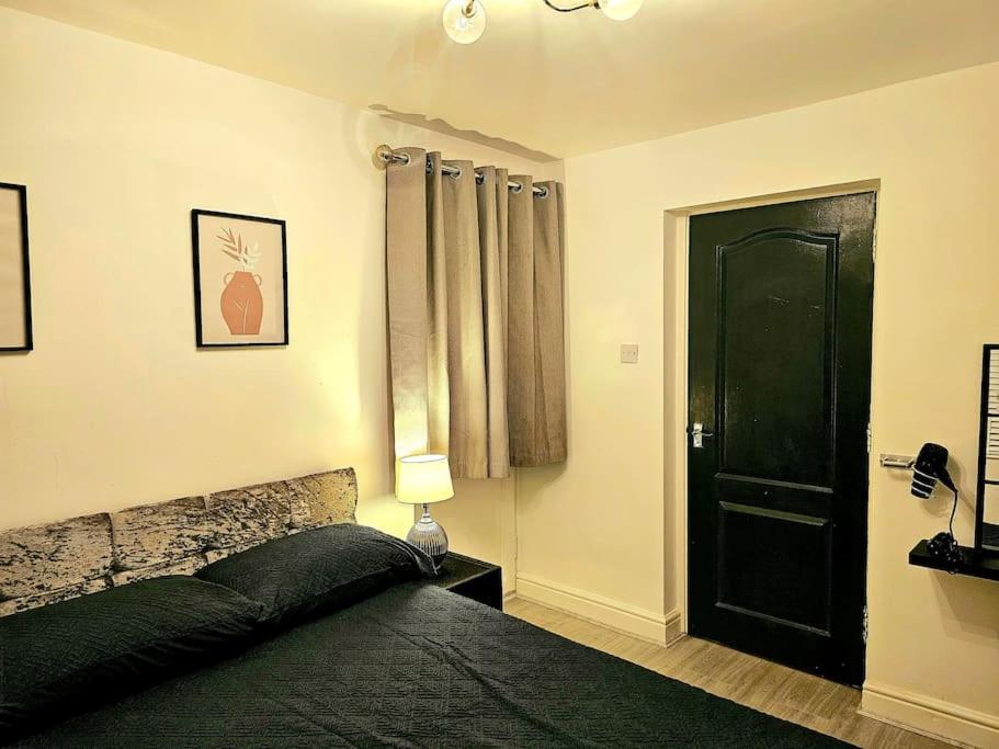 布里真德Modern & Cosy 1 bedroom flat的一间卧室设有一张黑色的床和一扇黑色的门