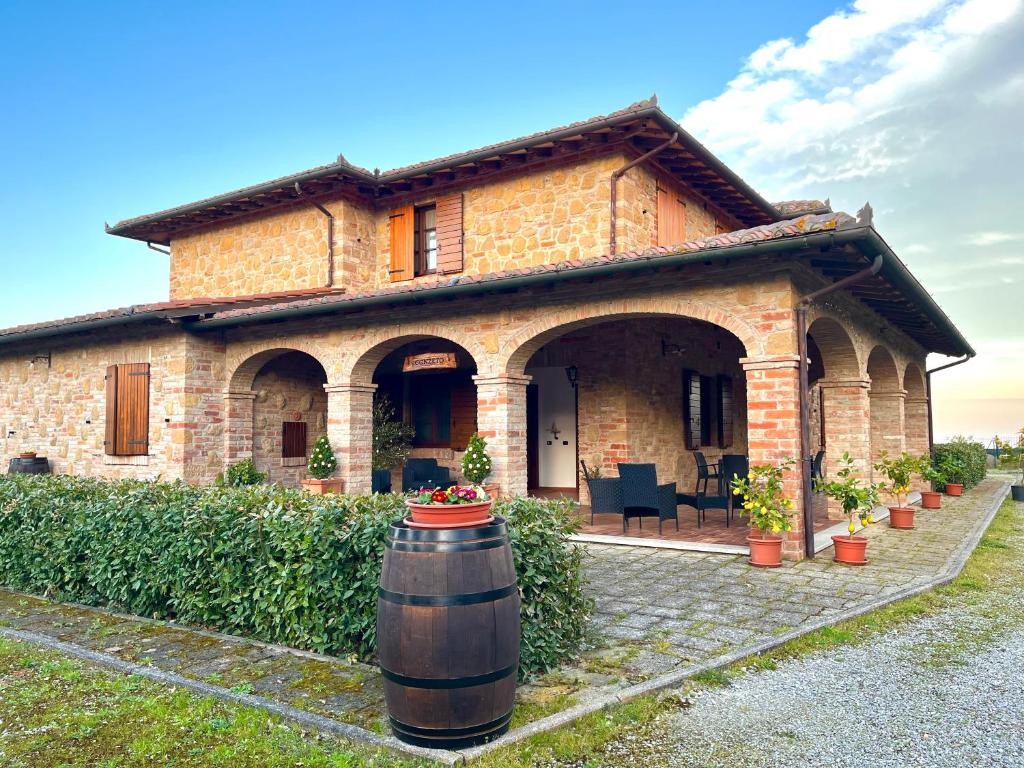 蒙特普齐亚诺Agriturismo Il Gonzeto, Montepulciano的前面有桶的大砖房子