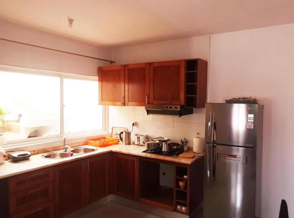 普拉亚Miras Guest House的厨房配有木制橱柜和不锈钢冰箱。