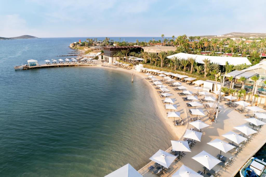 阿拉恰特Biblos Resort Alaçatı的享有海滩的空中景致,配有椅子和遮阳伞