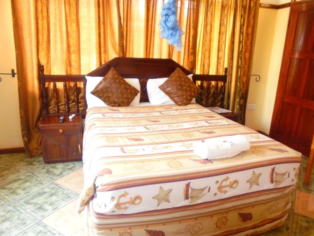 利文斯顿白玫瑰山林小屋的一间卧室配有一张大床和木制床头板