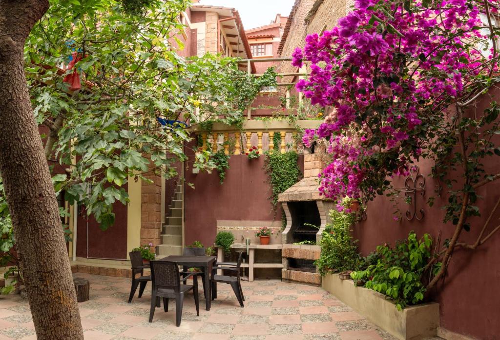 苏克雷Casa Martinez的庭院配有桌椅和紫色鲜花