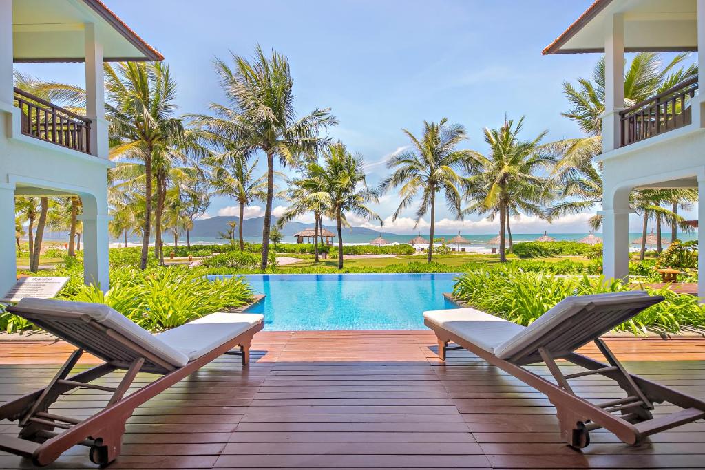 岘港Abogo Champa Villa Beach Da Nang的一个带椅子的度假甲板和一个游泳池