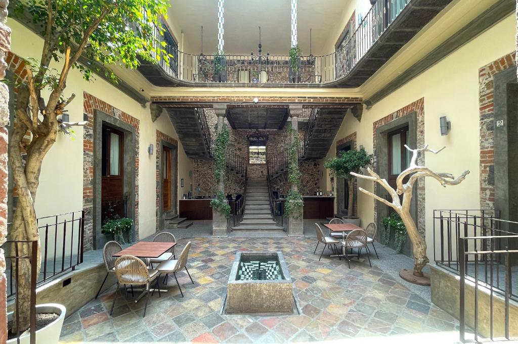 普埃布拉Milo Collection Hotel的庭院配有桌椅和喷泉