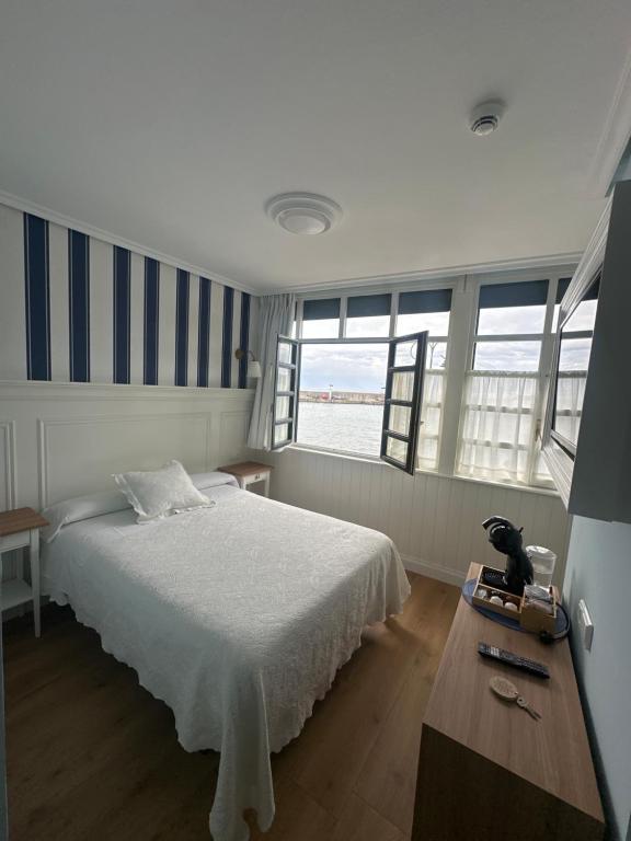 塔索内斯Hotel El Pescador的卧室配有床、桌子和窗户。