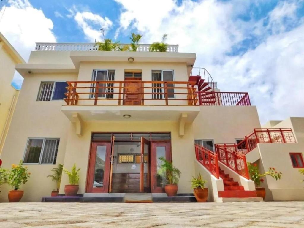 迪亚尼海滩Tranquil Pendo villas的前面有红色楼梯的房子