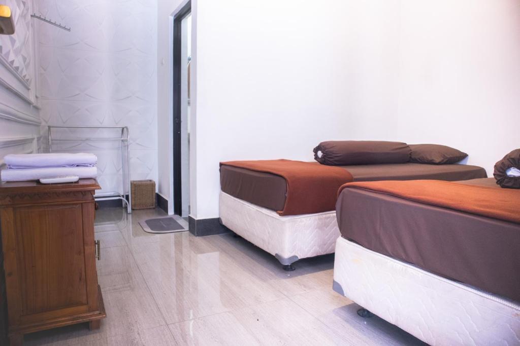 TimuranKAZAIN HOTEL的客房设有两张床和一张木桌。