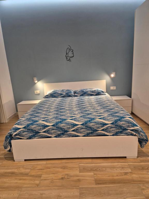 伊斯基亚Casa Vacanze Aenaria 2的卧室内的一张带蓝色和白色棉被的床