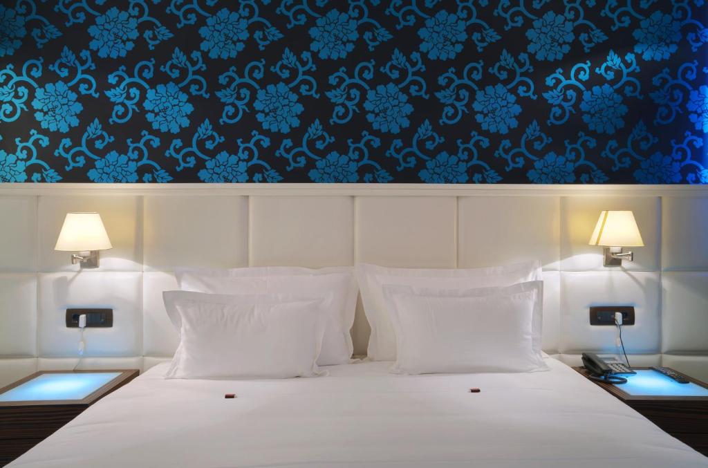 克拉列沃加尼水晶酒店的卧室配有白色床和蓝色壁纸