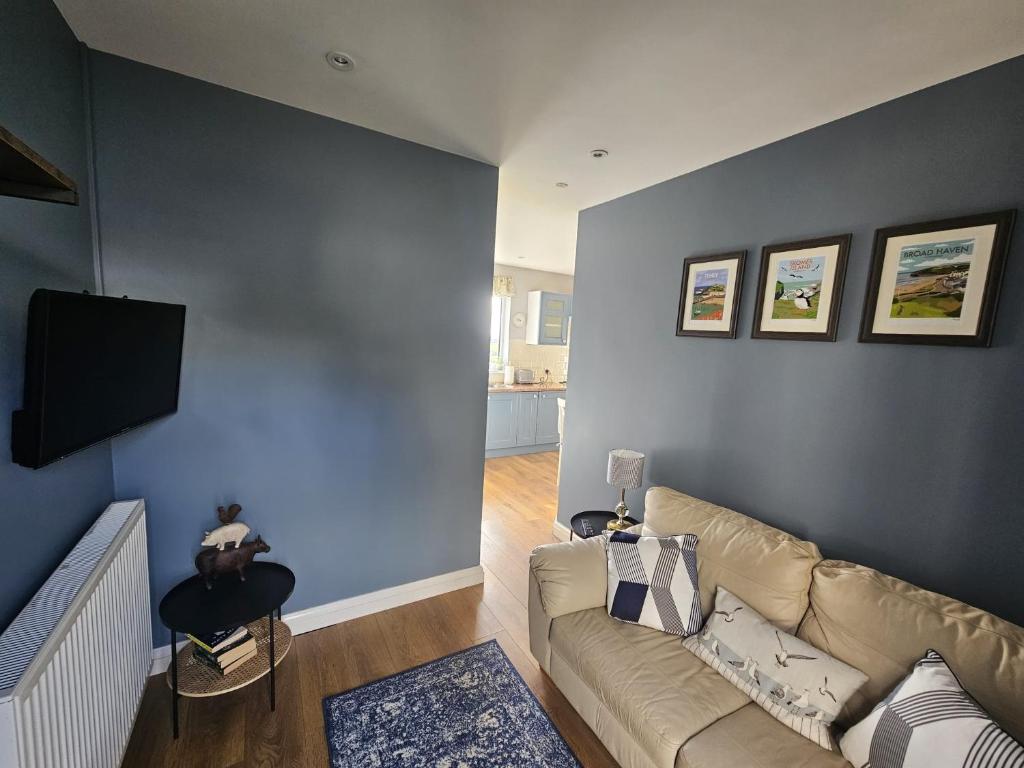 哈佛威斯特Meadow cottage的带沙发和蓝色墙壁的客厅