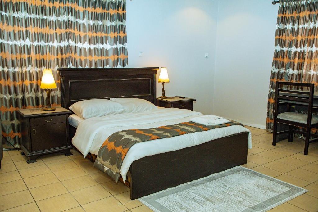 阿布贾Urban View Lodge - Apt.5 Room 1的一间卧室配有一张带2个床头柜的大床