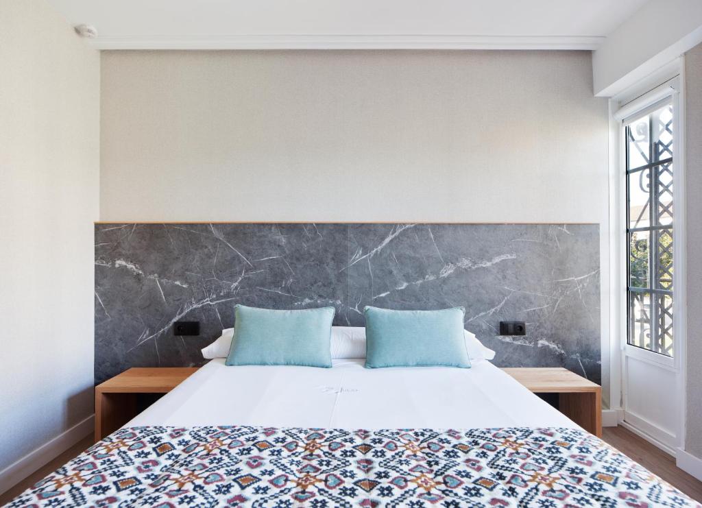圣地亚哥－德孔波斯特拉PR 25 德胡里奥酒店的一间卧室配有一张带蓝色枕头的大床