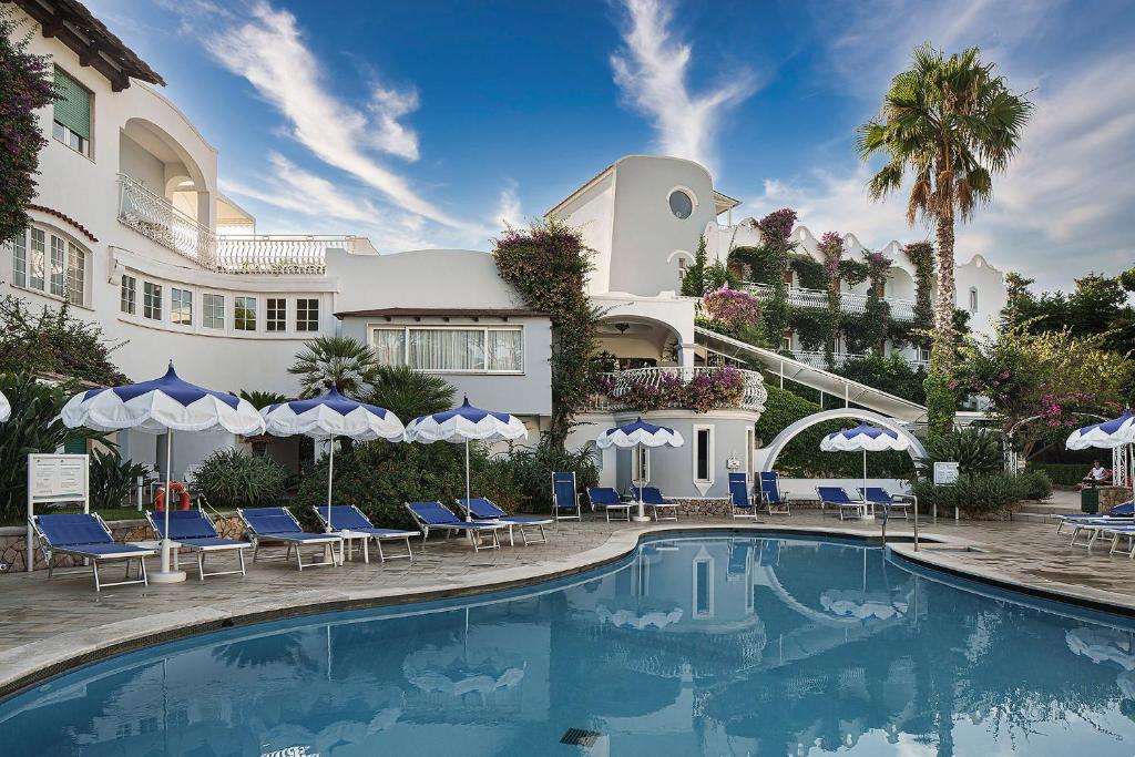 伊斯基亚伊斯基亚洲际酒店的酒店设有带椅子和遮阳伞的游泳池