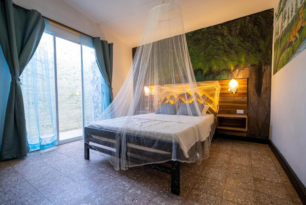 塔甘加Ambos Mundos Hotel Boutique的一间卧室配有一张带蚊帐的床