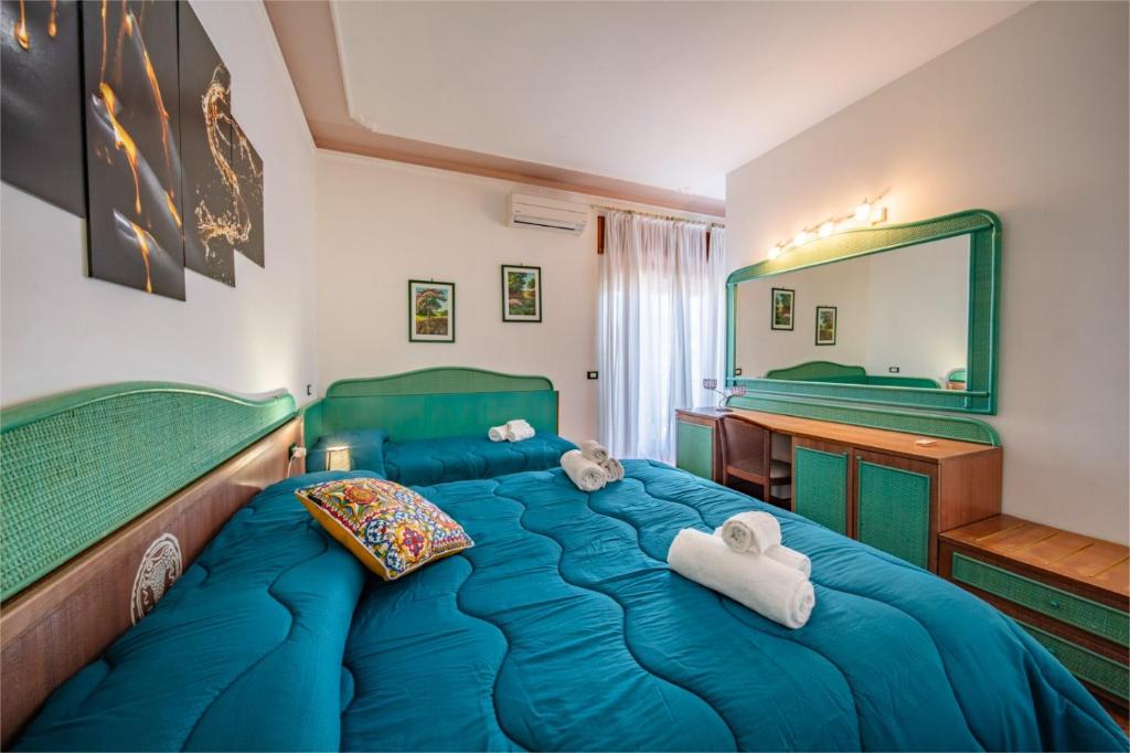陶尔米纳SUITE APARTMENT TAORMINA的一间卧室配有蓝色的床和镜子