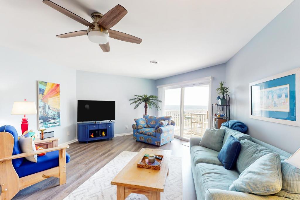 橡树岛Oceanview Bliss的客厅配有蓝色的沙发和吊扇