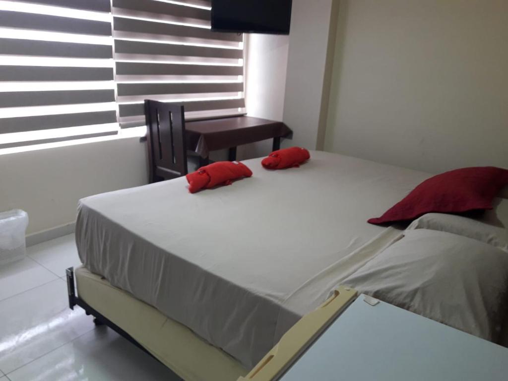 圣克鲁斯PRINCIPITO SANTA CRUZ的卧室里一张带两个红色枕头的床