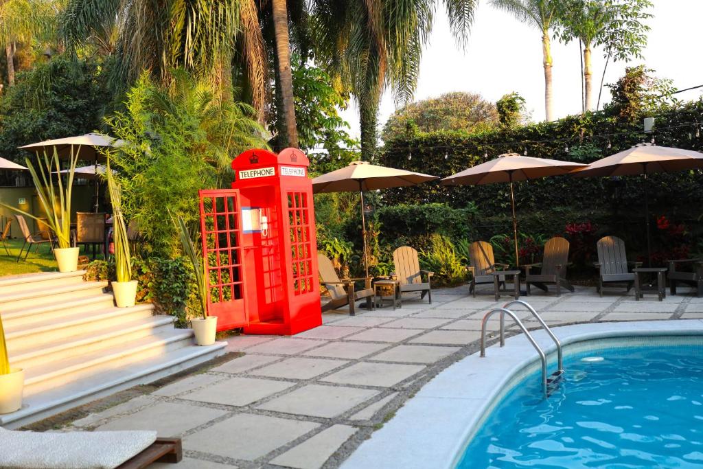 库埃纳瓦卡Hotel Grand Vista Cuernavaca的游泳池旁的红色电话亭
