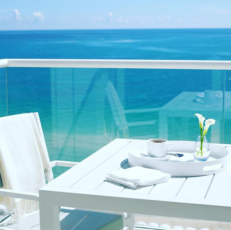 普拉亚登博萨Thee Ibiza Suites - Ushuaia Beach的白桌,杯,盘子上花