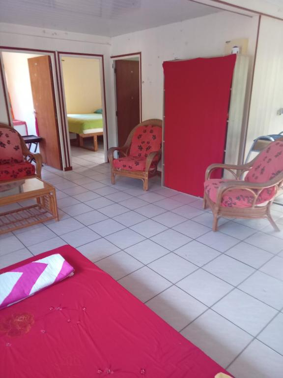 阿瓦托鲁Heimaruragi home的一间设有两把椅子和一张红色床单的房间
