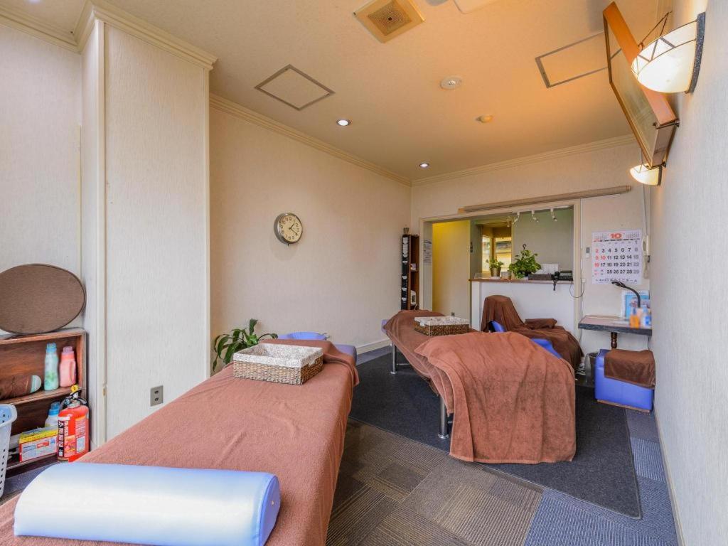 东京Itabashi Hotel Hilltop的一间医院间,配有两张床和镜子