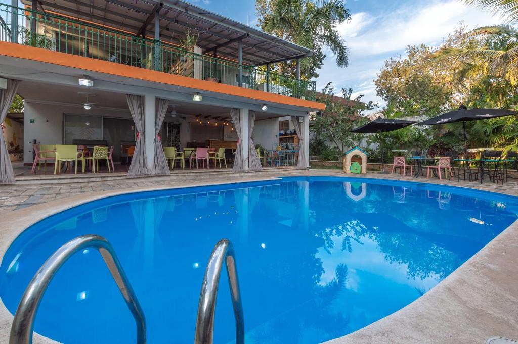 梅里达Jardín Mérida的酒店前方设有桌椅的游泳池