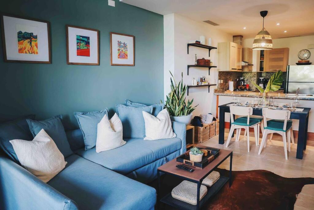 拉罗马纳Modern Condo in Casa de Campo的一间带蓝色沙发的客厅和一间厨房