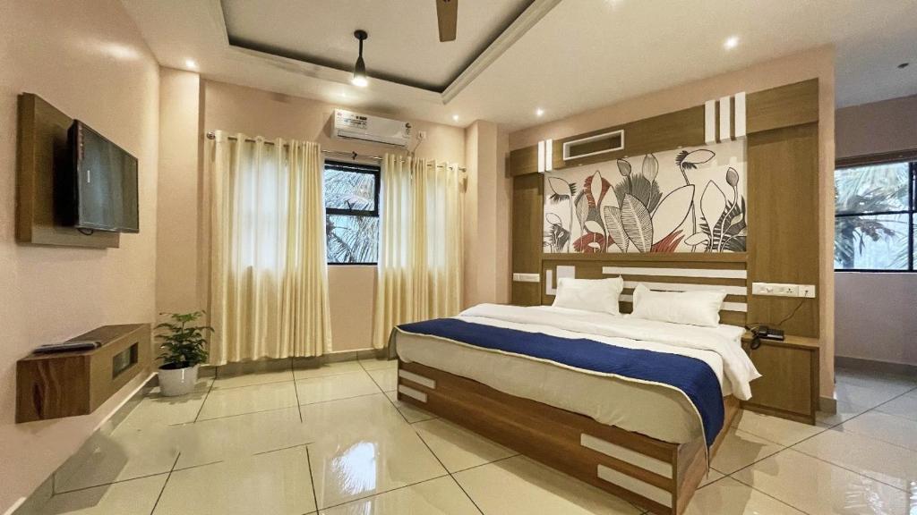 PinangodeIvyArk Residency的一间卧室配有一张大床和电视