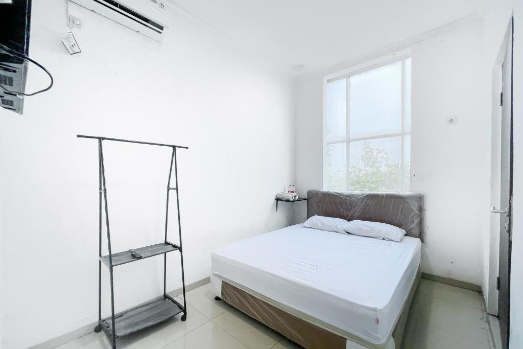 贝克西Citara Jaya Guesthouse Mitra RedDoorz的白色的卧室设有床和窗户