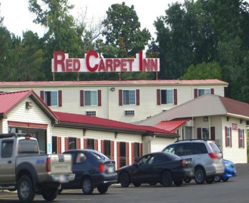 北锡拉丘兹锡拉丘兹机场红地毯旅店的一间红地毯旅馆,前面有汽车停放