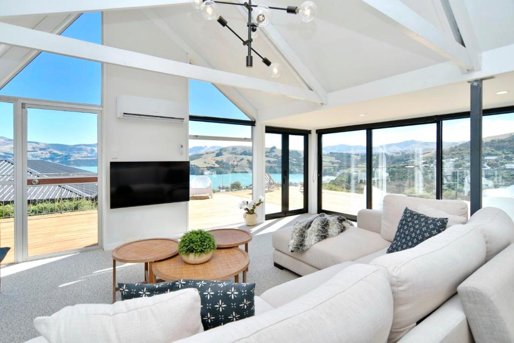 阿卡罗阿Akaroa Harbour View - Christchurch Holiday Homes的客厅配有白色家具和大窗户