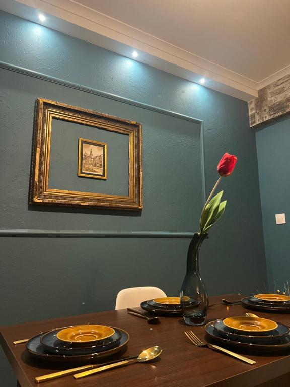 耶莱尼亚古拉Apartament Baron II *****的一张带板子的桌子和一个玫瑰花瓶